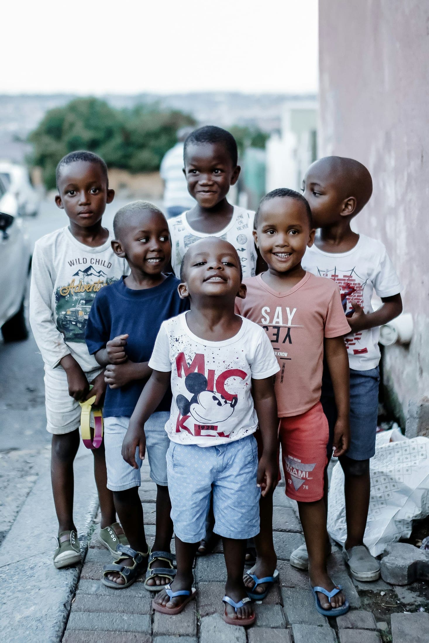 Six children standing together on a township street, looking toward the camera.